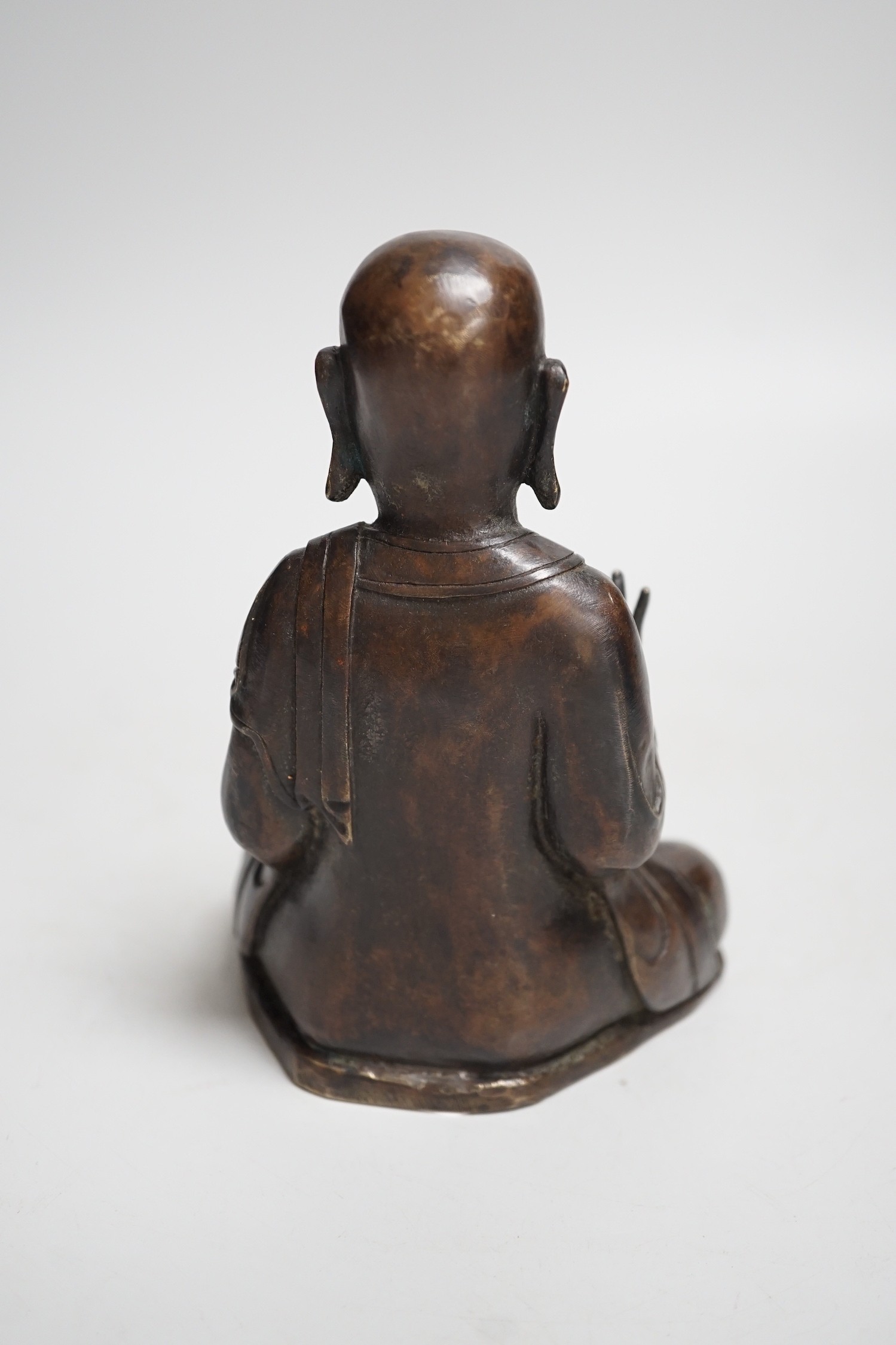 A Nepalese bronze figure of a seated immortal, probably 17th / 18th century, 16cm